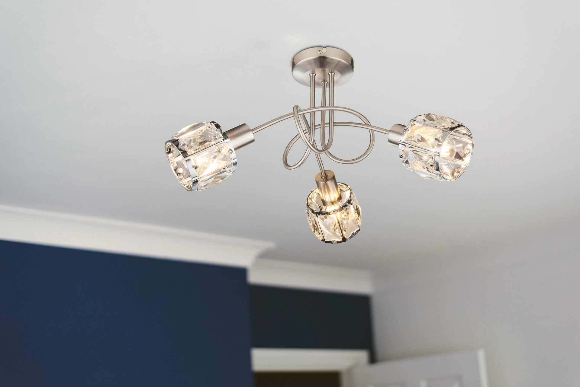 Deckenleuchte KRIS mit drei festen Strahlern aus facettiertem Glas, Arme Nickel matt, verchromte Metallfassungen, E14 für frei wählbare Leuchtmittel (LED empfohlen), Hersteller Globo Handels GmbH, Artikel 54356-3 – montiert an weißer Decke