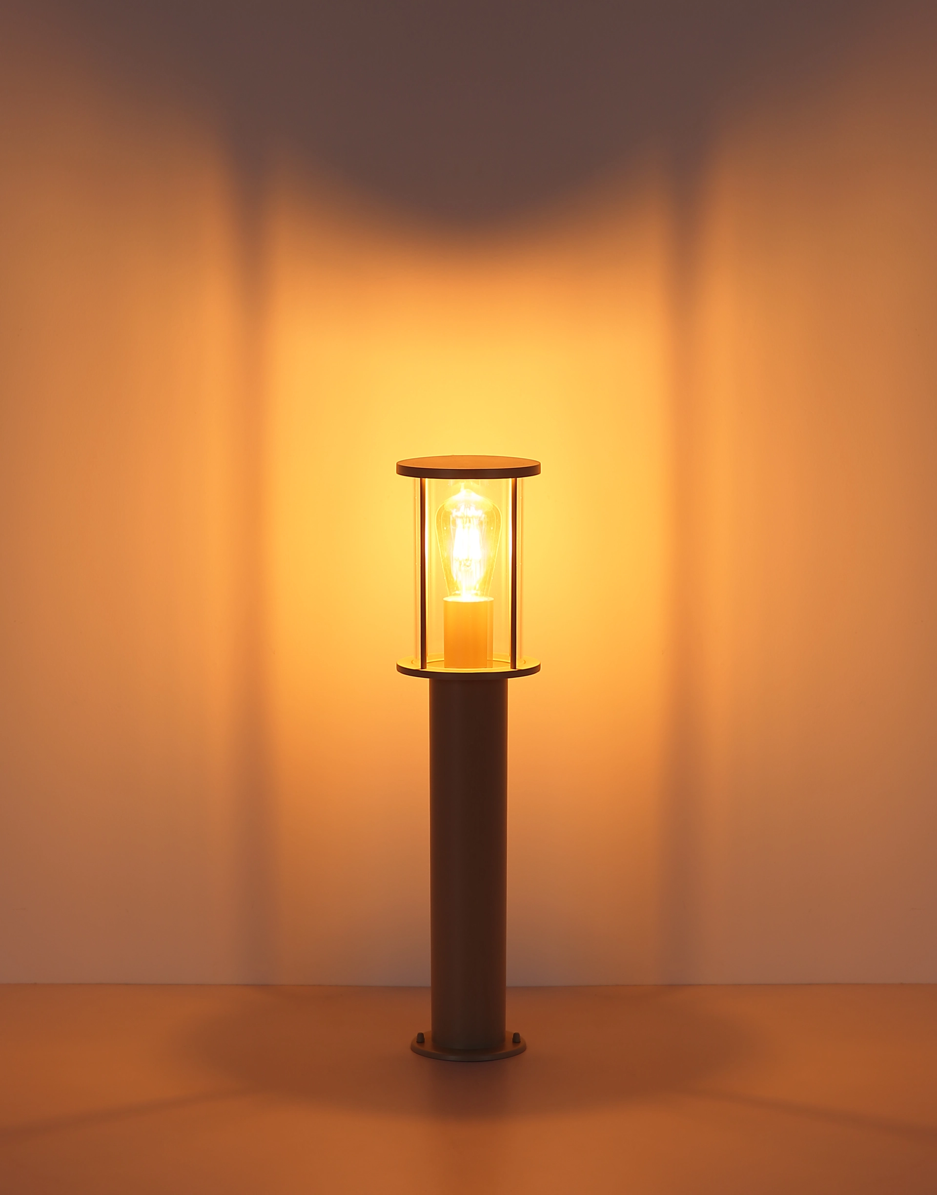 Luminaire extérieur GRACEY en acier inoxydable, finition sable martelé et verre clair émettant une lumière chaude