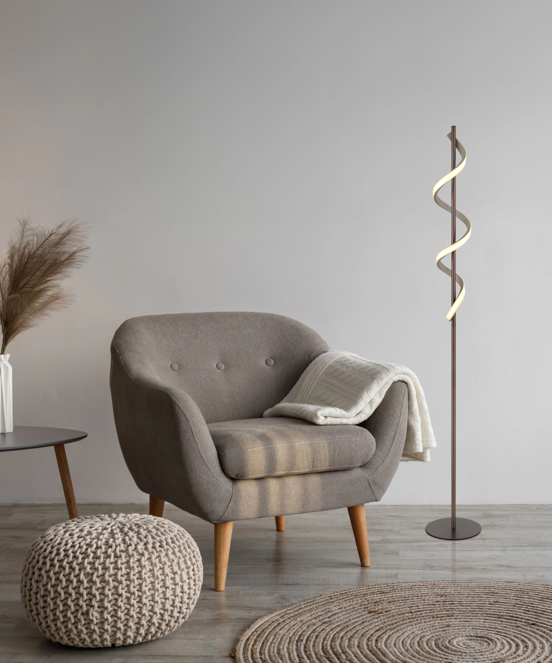 Stehleuchte SPIRO mit spiralförmiger LED neben Sessel im Wohnzimmer; schlankes Rohr aus Metall kaffeefarben matt, Schirm aus Kunststoff sandfarben matt mit opalen Elementen; modernes Design von Globo Handels GmbH, Modell 67384S