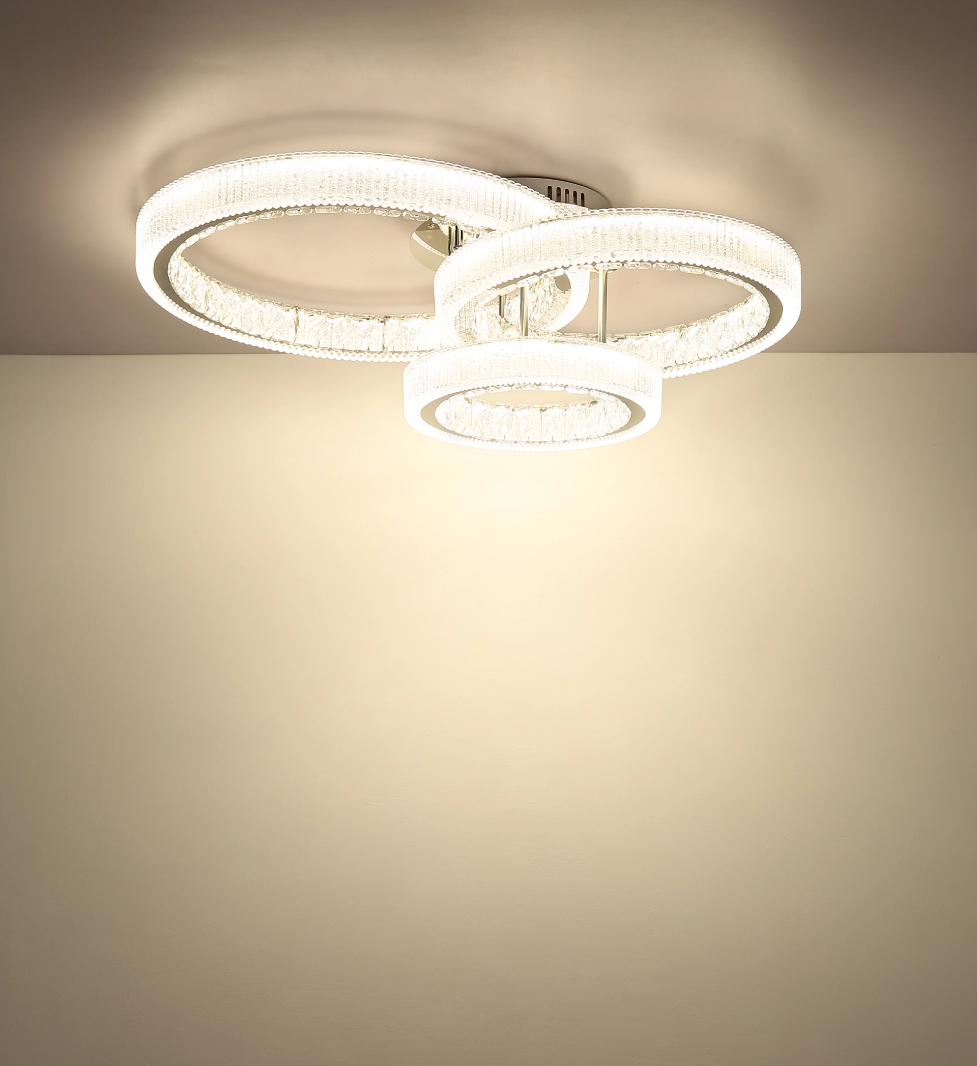 Deckenansicht der LUMINARA Deckenleuchte von Globo Handels GmbH: verchromter Edelstahl, transparente Acrylringe mit Kristall-Effekt, Modell 67395-72, leuchtende, überlappende LED-Ringe für elegantes Raumlicht.